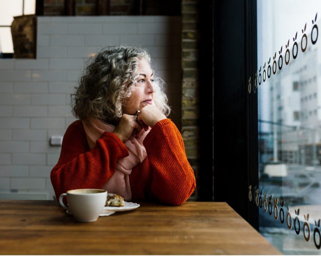 Portrait of Monica Cohn at a café table