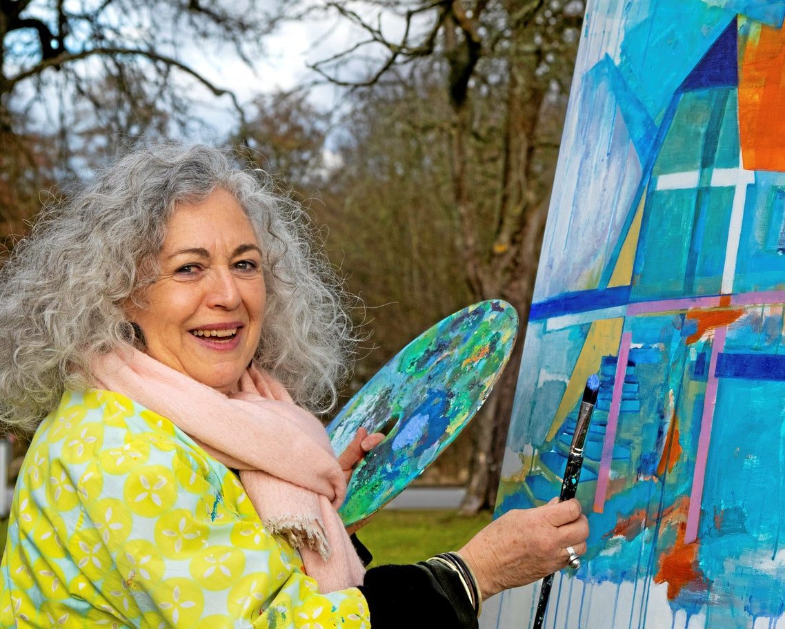Monica Cohn painting outdoors, palette in hand